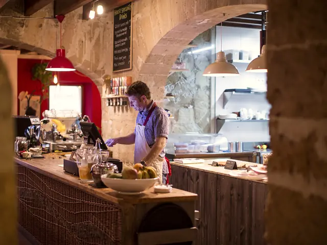 A man working behind the counter of a small shop.