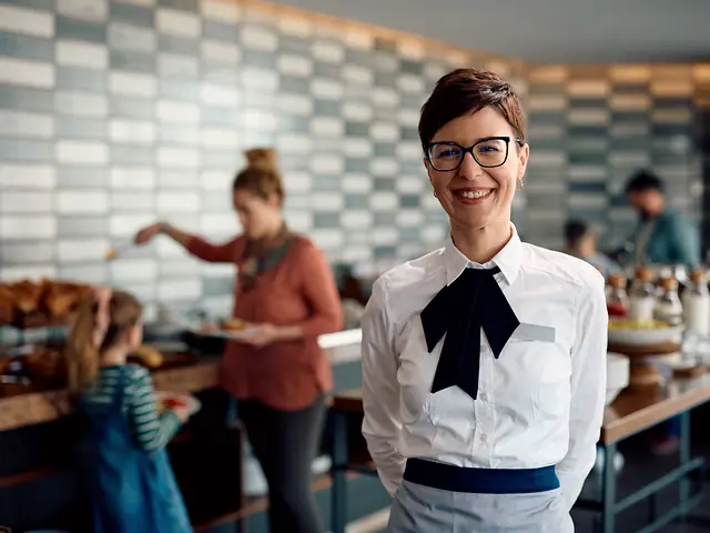 A staff member in a hotel breakfast room.